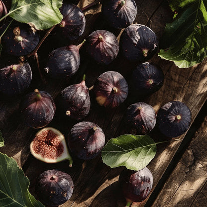 Black Jack Figs with green leaves on a wooden surface
